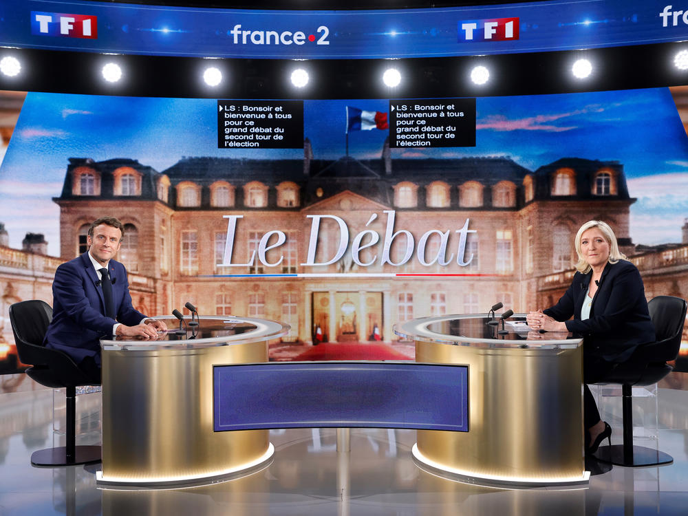 Centrist candidate and French President Emmanuel Macron, left, and far-right contender Marine Le Pen pose before a televised debate in La Plaine-Saint-Denis, outside Paris, Wednesday, April 20, 2022.