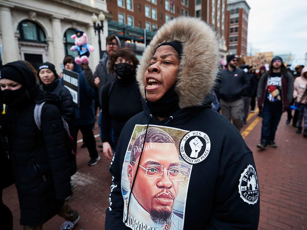 A woman wears a sweater with an image of Patrick Lyoya as protesters march for Lyoya in downtown Grand Rapids on Saturday.