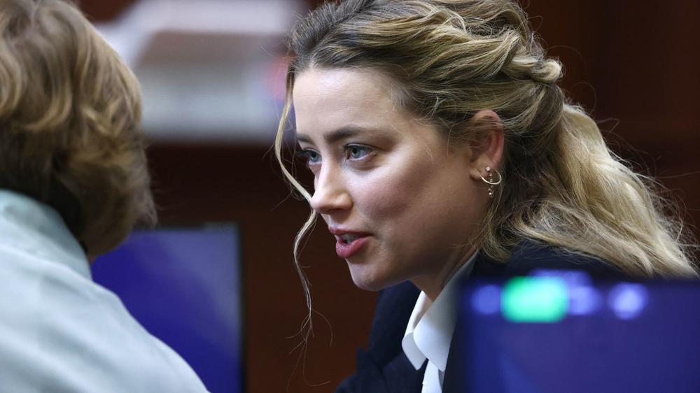 Actress Amber Heard speaks to her attorney during the defamation trial against her at the Fairfax County Circuit Courthouse in Fairfax, Va., on Thursday.