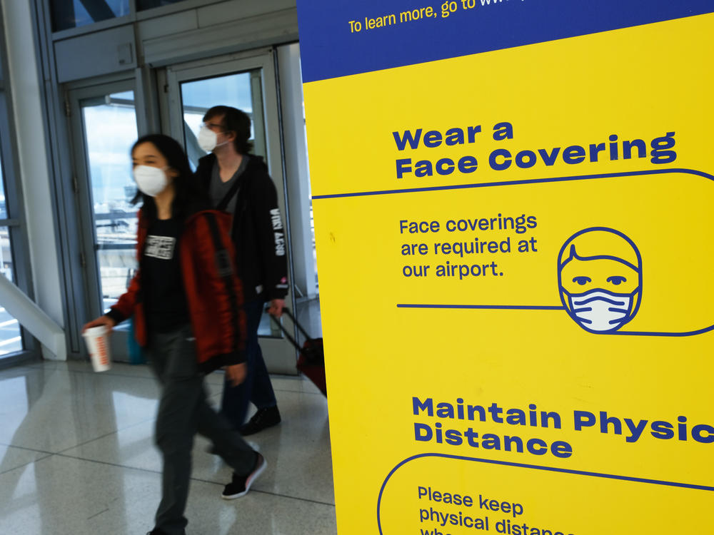 People enter wearing masks at John F. Kennedy Airport on April 19 in New York City. On Monday, a federal judge in Florida struck down the mask mandate for airports and other methods of public transportation as a new COVID variant is on the rise across parts of the United States.