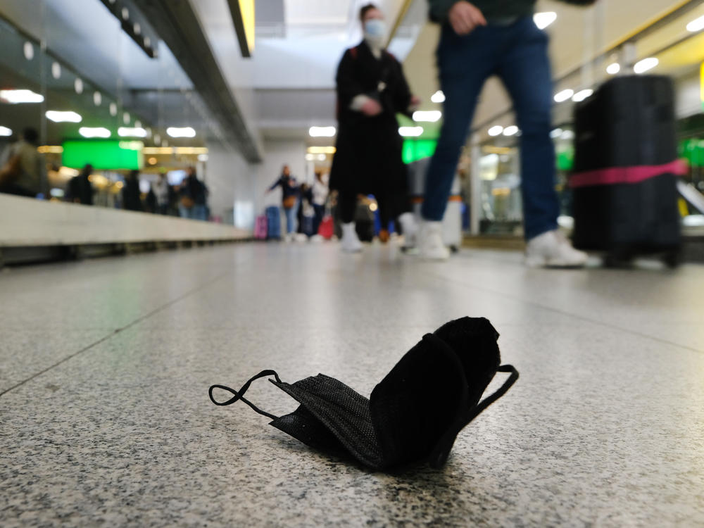A discarded mask is seen on the floor inside New York's John F. Kennedy Airport on Tuesday, a day after a federal judge in Florida struck down the CDC's mask mandate for public transportation.