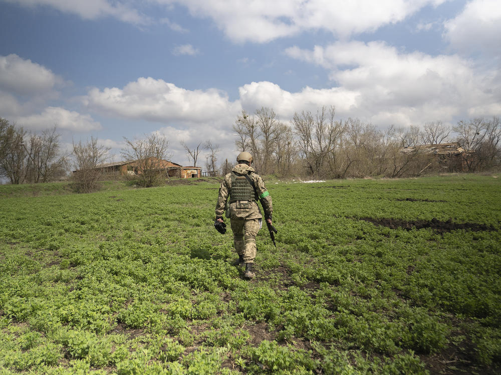 Capt. Daniil, a public affairs officer in the Ukrainian military, walks through a field in Mala Rohan, on the outskirts of Ukraine's northeastern city of Kharkiv. He is recording the aftermath of fighting between occupying Russian soldiers and Ukrainian forces.