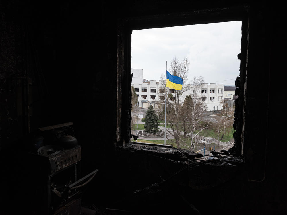A Ukrainian national flag is seen through a window of a destroyed apartment, on Thursday in Borodianka, Ukraine.