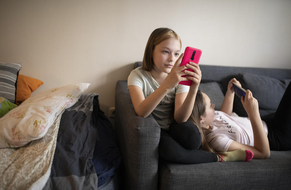 Oleksandra Nykolyn, left, and her sister Julija, right, use smartphones at their apartment in Sofia, Bulgaria, on Friday, April 22.