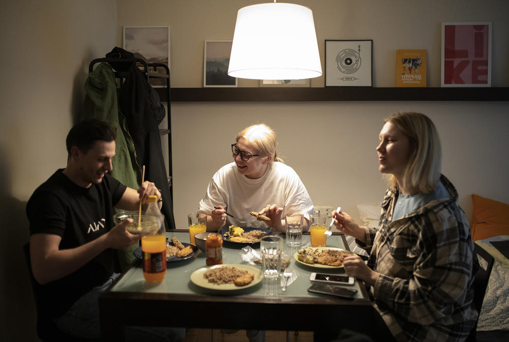 Josif Feny, left, Anet Pchelnikova, right, Natasha Nykolyn, center, have dinner at their apartment in in Sofia, Bulgaria, on Friday, April 22.