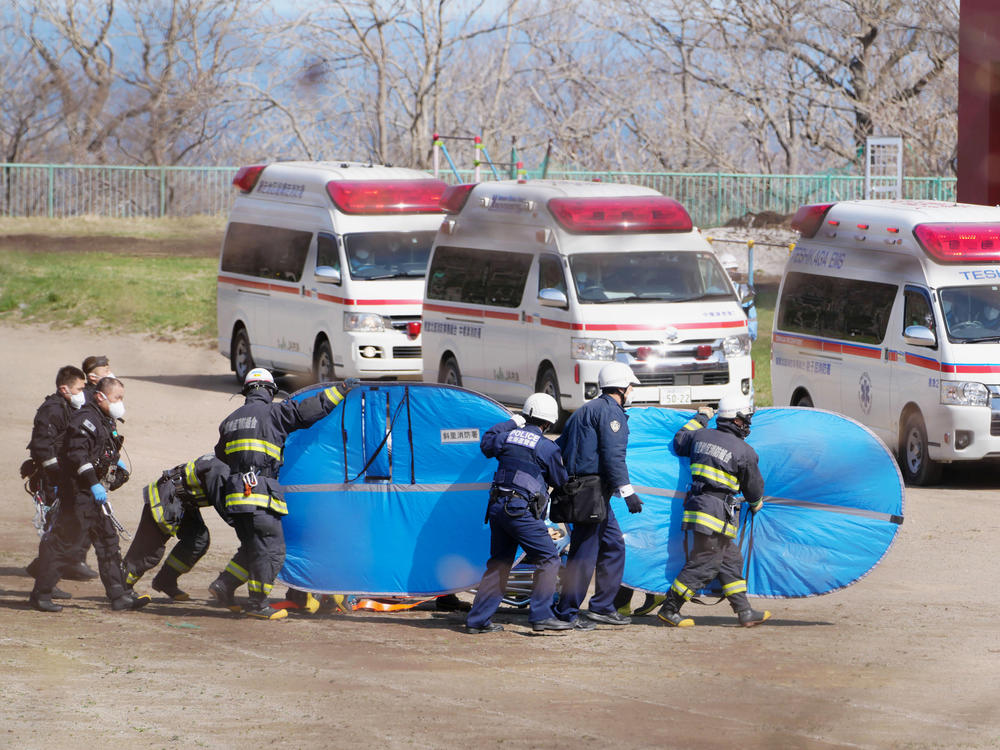 Firefighters transfer a rescued person in Shari, in the northern island of Hokkaido on Sunday.