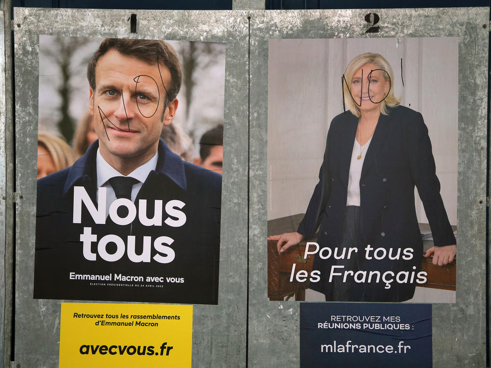 Presidential campaign posters of French President and centrist candidate for reelection Emmanuel Macron, left, and French far-right presidential candidate Marine Le Pen, in Salies de Bearn, southwestern France, Saturday, April 23, 2022.