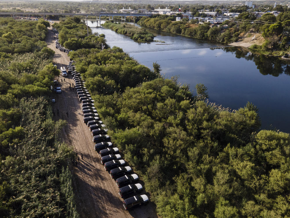A line of Texas Department of Safety vehicles line up on the Texas side of the Rio Grande. Texas Gov. Greg Abbott launched Operation Lone Star last year to crack down on unauthorized border crossings into the U.S.