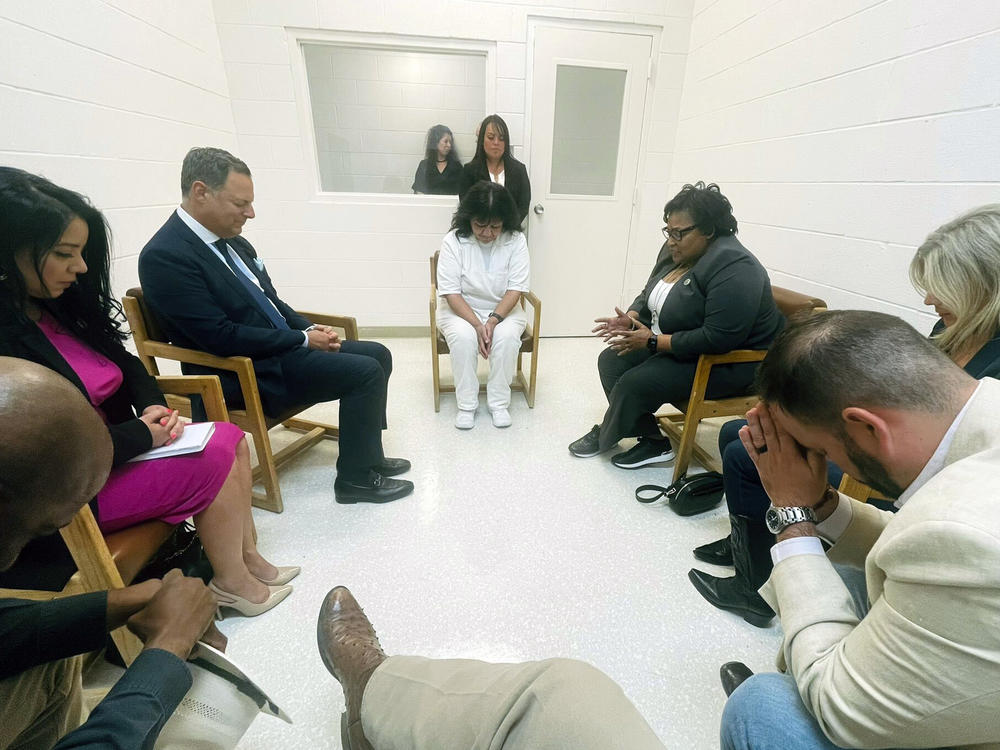 In this April 6, 2022 photo provided by Texas state Rep. Jeff Leach, Texas death row inmate Melissa Lucio, dressed in white, leads a group of seven Texas lawmakers in prayer in a room at the Mountain View Unit in Gatesville, Texas.