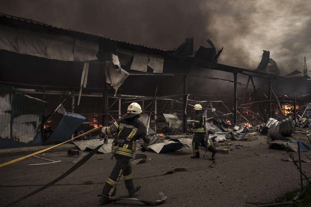 <strong>April 23:</strong> Firefighters work to extinguish a fire on a warehouse amid Russian bombardments in Kharkiv, Ukraine.