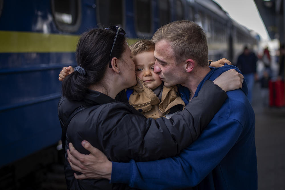 <strong>April 23:</strong> Oleksandr, 26 kisses his soon Egor, 2, and his wife Alyona, 26, as they meet at the train station after more than two months separated for the war in Kyiv, Ukraine.