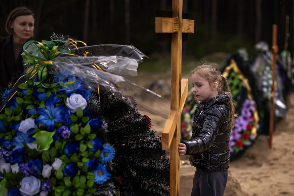 <strong>April 25:</strong> Darya Piven, 33, looks as her daughter Zlata, 6, as she visits the graves of her parents Nadiya Myakushko, 69, and Volodymyr Cherednichenko, 75, who were killed by Russian army in Irpin on March 24, in Irpin, on the outskirts of Kyiv.