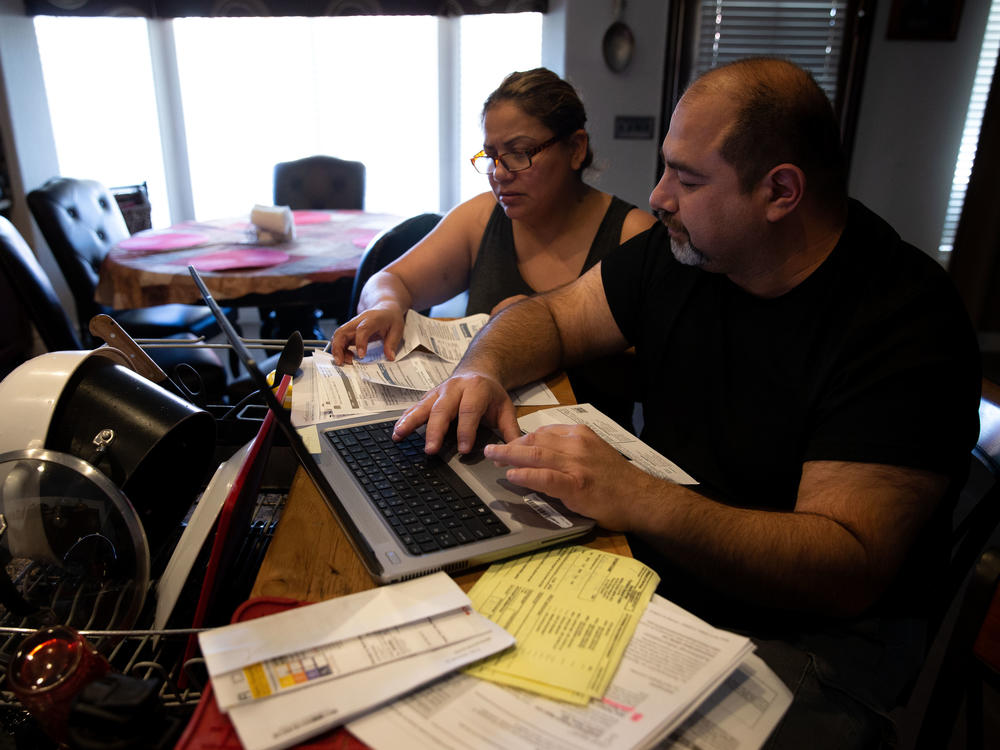 Claudia and Jesús Fierro of Yuma, Ariz., review their medical bills. They pay $1,000 a month for health insurance yet still owed more than $7,000 after two episodes of care at the local hospital.