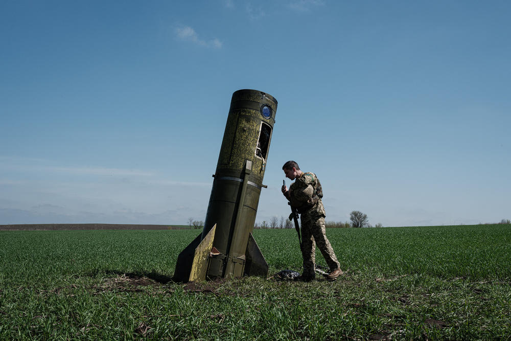 <strong>April 25:</strong> A Ukrainian serviceman looks at a Russian ballistic missile's booster stage that fell in a field in Bohodarove, in eastern Ukraine.