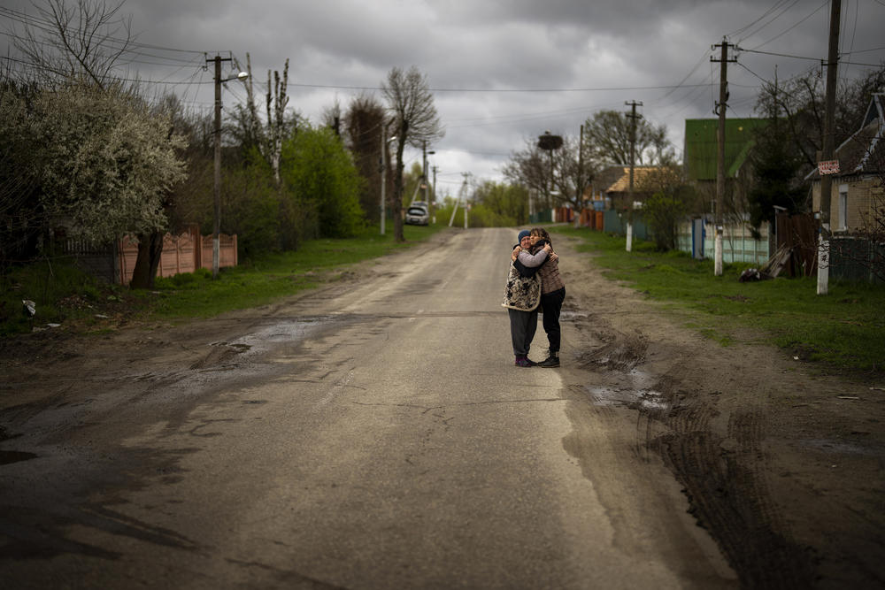 <strong>April 26:</strong> Tetyana Boikiv, 52, (right) meets and hugs her neighbor Svitlana Pryimachenko, 48, during a funeral service for her husband, Mykola Moroz, 47, in the Ozera village, near Bucha, Ukraine.