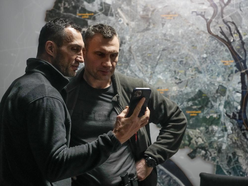 Kyiv Mayor Vitali Klitschko (right) and his brother Wladimir Klitschko check a phone at city hall on Feb. 27. When Russia invaded Ukraine, many expected Moscow to knock out the Ukrainian communications network. But Ukrainian systems, for both civilians and the military, continue to function. Ukraine, meanwhile, has regularly intercepted Russian military communications.