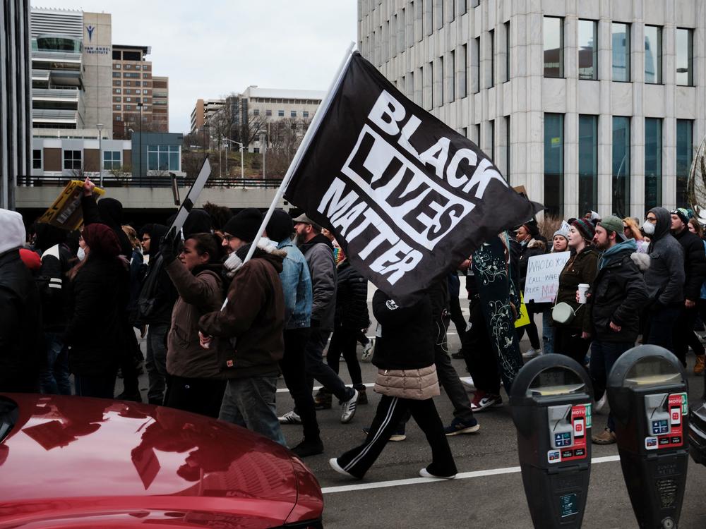 Protesters hold a Black Lives Matter flag as they march for Patrick Lyoya, a Black man who was fatally shot by a police officer, in downtown Grand Rapids, Mich.