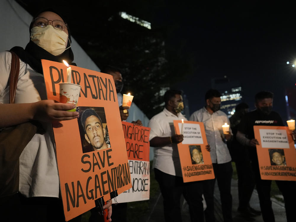 Activists holds posters against the impending execution of Nagaenthran K. Dharmalingam, sentenced to death for trafficking heroin into Singapore, during a candlelight vigil gathering outside the Singaporean Embassy in Kuala Lumpur, Malaysia, Tuesday, April 26, 2022.