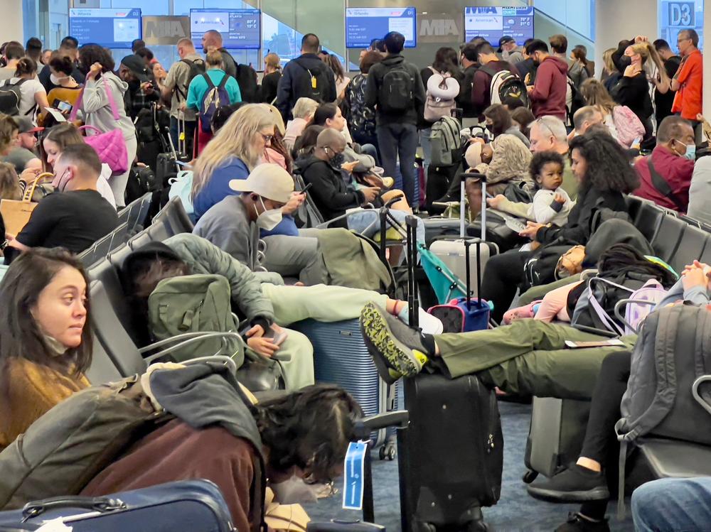 Dr. Anthony Fauci, chief medical adviser to President Biden, cites the U.S. vaccination program and previous widespread transmission of the coronavirus as reasons why the U.S. is not now under pandemic conditions. Here, travelers wait at Miami International Airport last week after mask requirements were lifted.