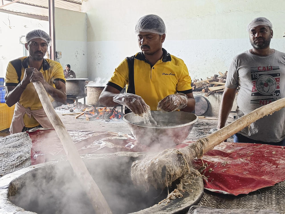 Workers pound the steaming mixture of meat, lentils, wheat and spices with long wooden paddles to give the haleem its signature smooth texture.