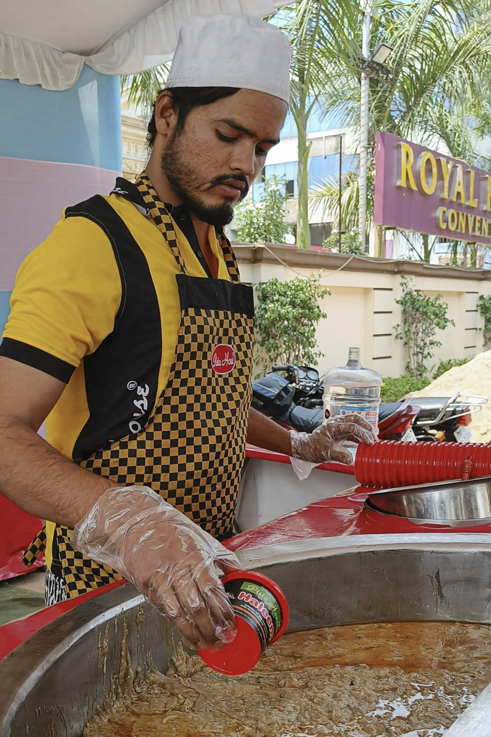 A few hours before the Ramadan fast is broken, a fresh batch of haleem is ready to be served. A worker fills takeout containers with piping hot haleem topped with clarified butter and fried onions.