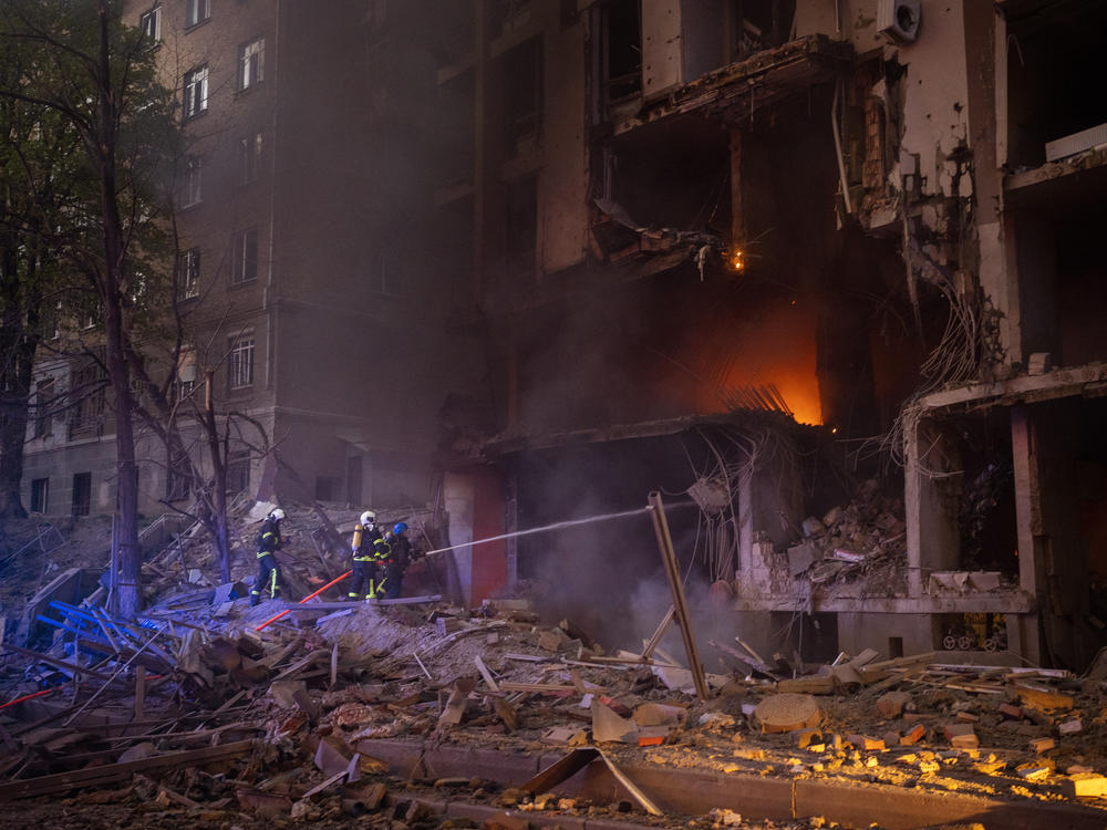 Firefighters try to put out a fire following an explosion in Kyiv on Thursday, the same day of a visit by the head of the United Nations.