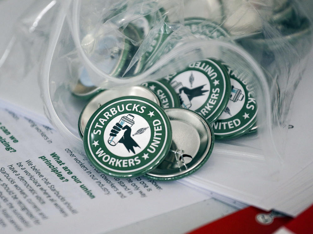 Pro-union pins sit on a table during a watch party for Starbucks' employees union election, Dec. 9, 2021, in Buffalo, N.Y. The top lawyer for the National Labor Relations Board said Thursday, April 7, she will ask the board to rule that mandatory meetings some companies hold to persuade their workers reject unions is in violation of federal labor law.