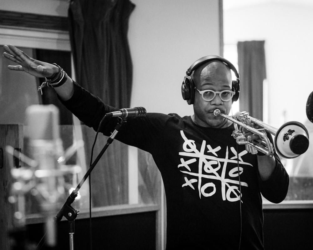 Etienne Charles conducts while playing, for the album 