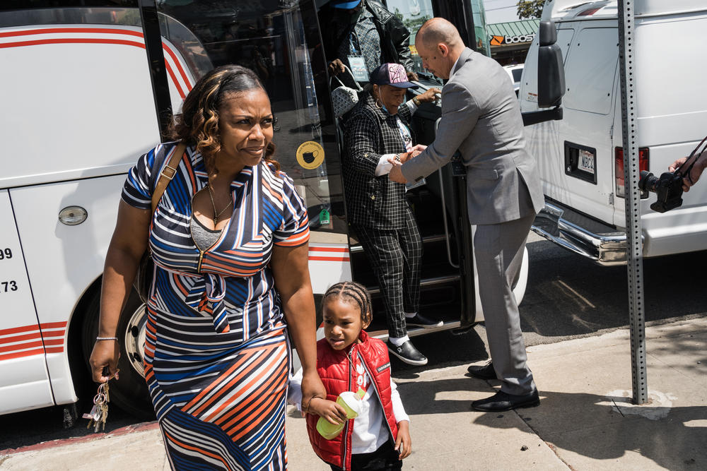 Lora King, daughter of Rodney King and CEO of the Rodney King Foundation, and her son, Raymond Price, 2, exit a tour bus before the start of the press conference.