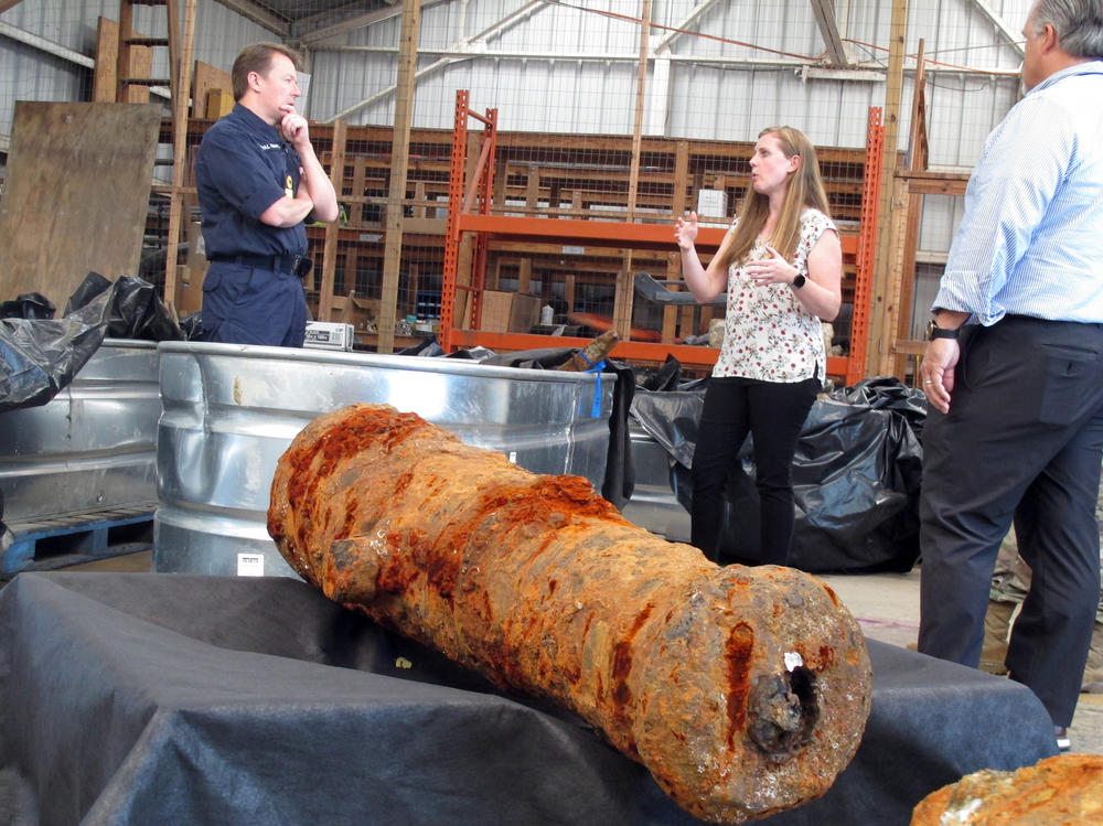 Commodore Philip Nash (left) of the British Royal Navy gets a briefing from U.S. Army Corps of Engineers archaeologist Andrea Farmer on Thursday in Savannah, Ga., about 19 cannons recovered from the Savannah River, that experts suspect came from one or more British ships scuttled in the river in 1779.