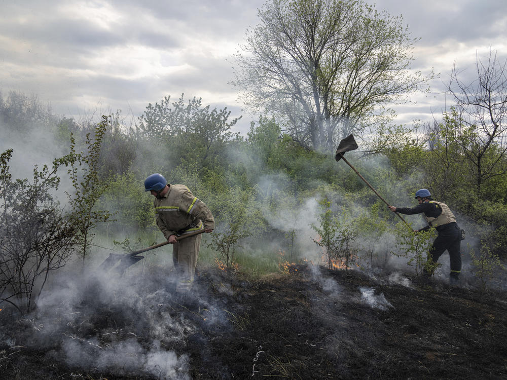 Rescue servicemen extinguish a bush fire after shelling in Mykolaivka, Donetsk region, eastern Ukraine, on Friday.