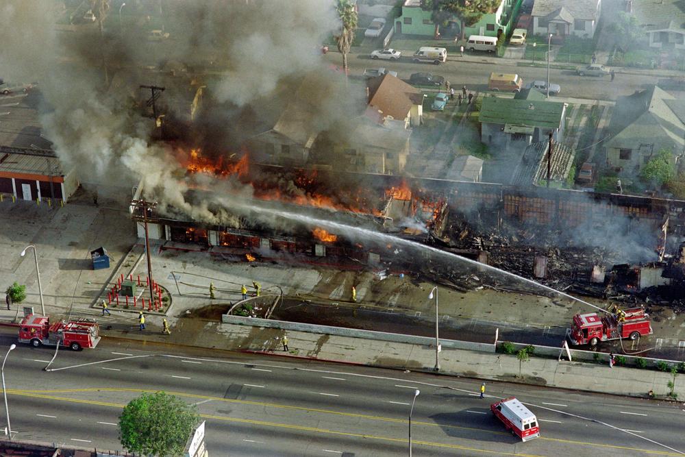 Firefighters extinguish a fire during the rioting in Los Angeles, on April 30, 1992.