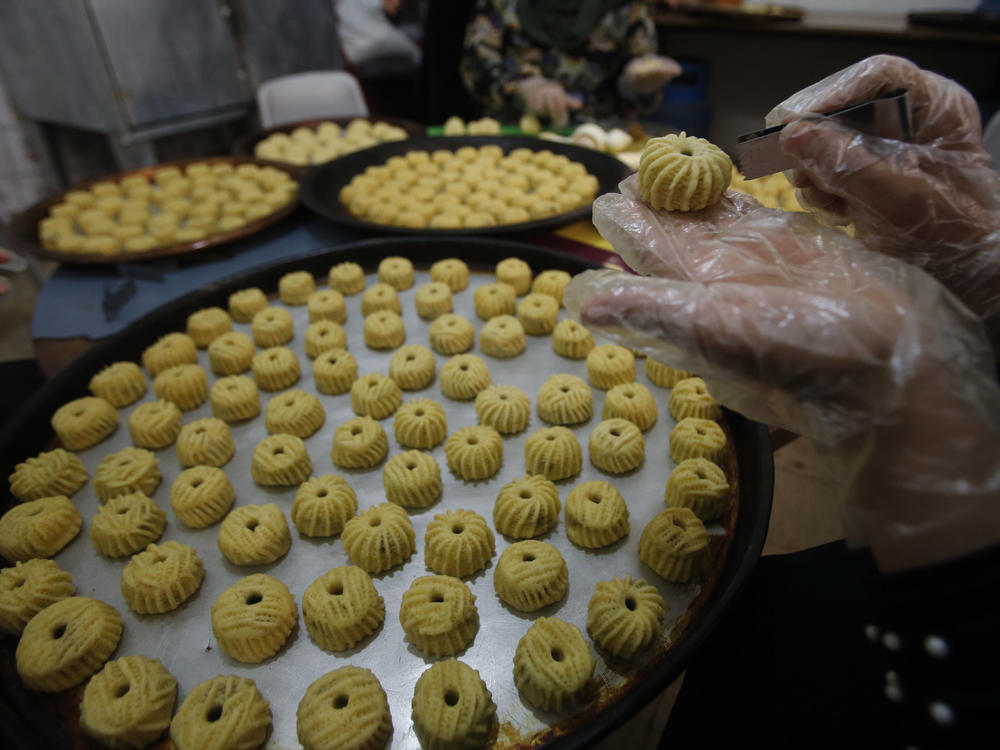 Palestinian women make traditional pastries filled with dates or nuts known as ma'amoul.