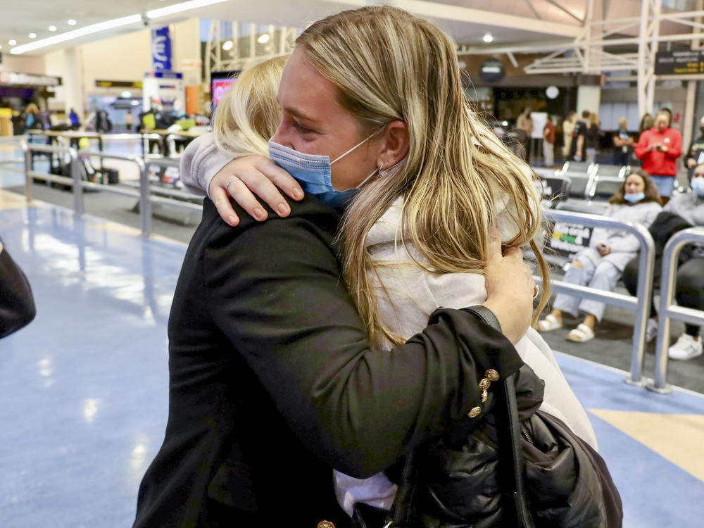 Families embrace after a flight from Los Angeles arrived at Auckland International Airport as New Zealand's border opened for visa-waiver countries Monday, May 2, 2022.