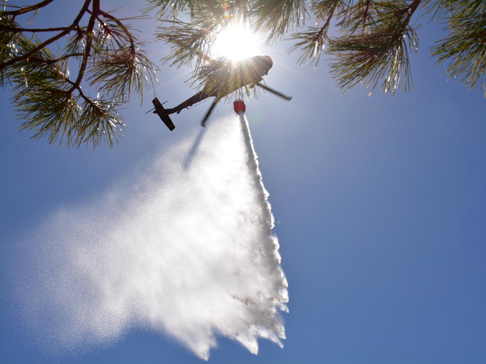 New Mexico National Guard Aviation soldiers execute water drops as part of firefighting efforts, dropping thousands of gallons of water on the Calf Canyon/Hermits Peak fire in northern New Mexico on Sunday.