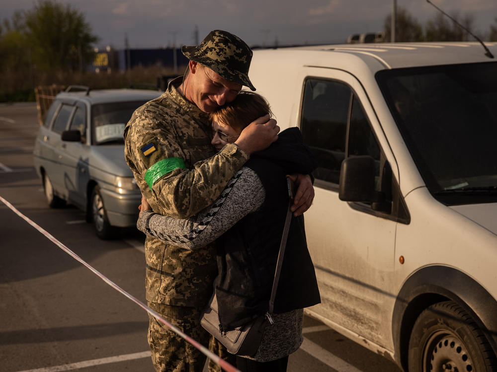 Hryhorii, a member of the Ukrainian military, hugs his wife Oksana, whom he had not seen for nearly a year, after she fled from the Russian-occupied Novomykhailivka village and arrived by car at an evacuation point for people fleeing Mariupol, Melitopol and the surrounding towns under Russian control, on Monday, in Zaporizhzhia, Ukraine.