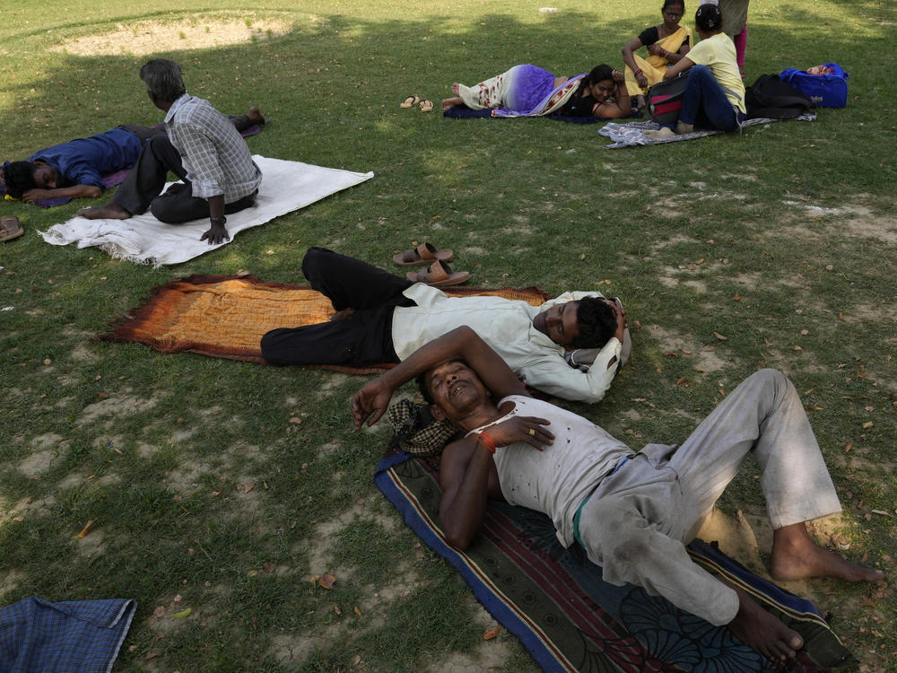 People rest in the shade of a tree on a hot summer afternoon in Lucknow in the central Indian state of Uttar Pradesh, on Thursday. Severe heat wave conditions are sweeping north and western parts of India.