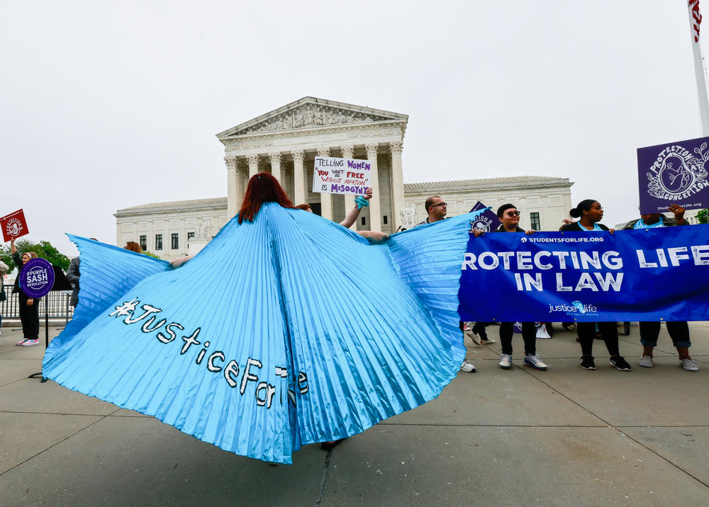 Protesters stand outside the U.S. Supreme Court building Tuesday after a leaked draft decision suggested a majority of the court's justices would vote to overturn <em>Roe v. Wade</em>.