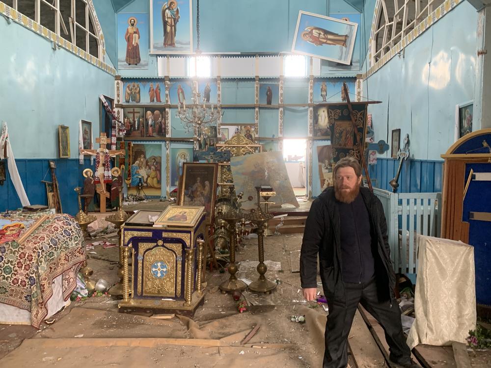 Father Oleksandr Yarmolchyk stands inside the demolished nave of his Orthodox church in Peremoha, Ukraine on April 17. He says the Russians bombed his church and held him against his will.