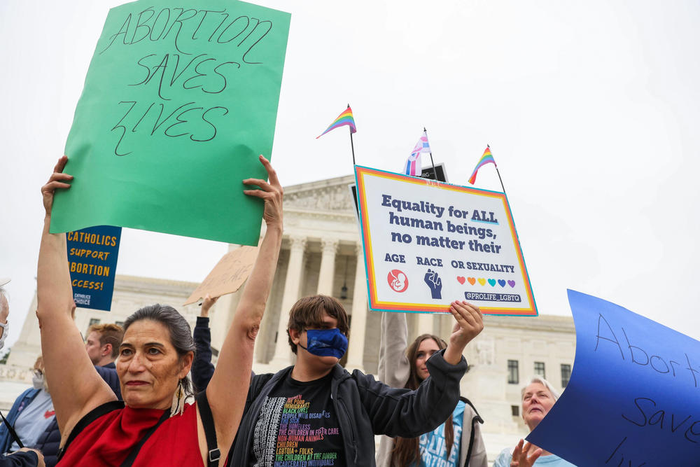 Protesters stand outside the U.S. Supreme Court building Tuesday.