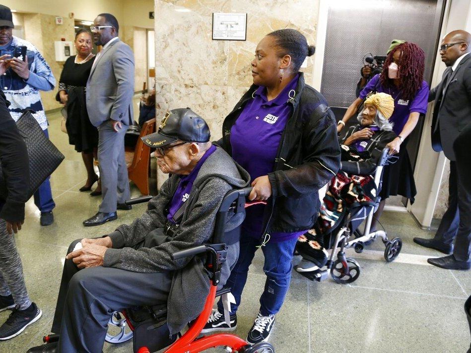 Hughes Van Ellis, 101, foreground left, and Lessie Benningfield Randle, 107, right, survivors of the 1921 Tulsa Race Massacre, outside a courtroom on Monday at the Tulsa County Courthouse, in Tulsa, Okla.
