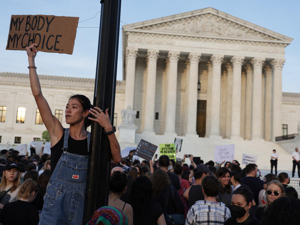 A person holds a sign during a rally in front of the Supreme Court on Tuesday in response to its leaked draft decision to overturn <em>Roe v. Wade</em>.