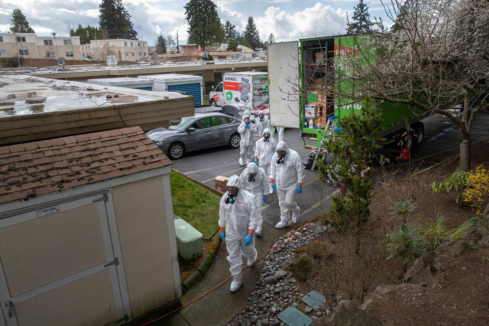 A cleaning crew wearing protective clothing enters the Life Care Center in Kirkland, Wash., in March 2020. The nursing home had some of the earliest deaths in the U.S. due to COVID.