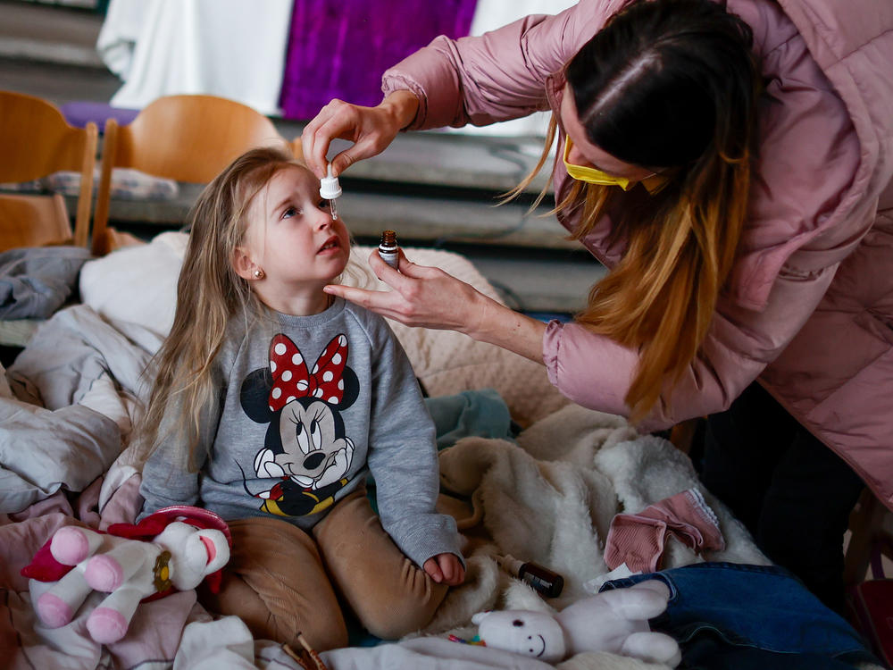 Ukrainian refugee Alina Archipova gives her daughter medication at a temporary shelter in Berlin, Germany, on March 10.