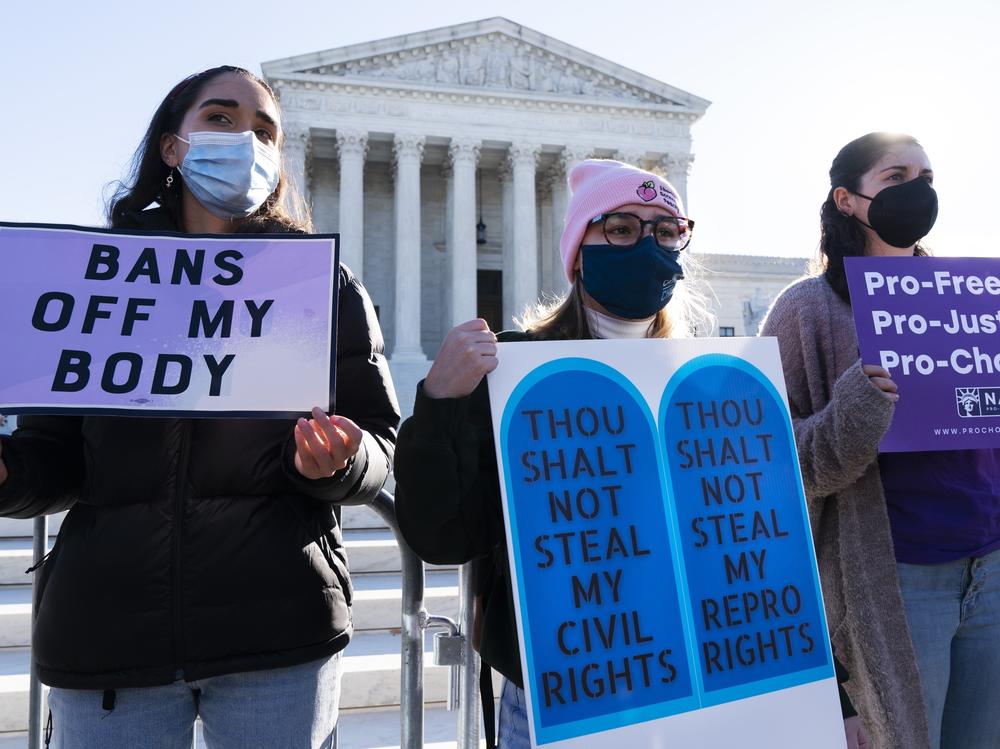 Caroline McDonald, left, a student at Georgetown University, Lauren Morrissey, with Catholics for Choice, and Pamela Huber, of Washington, join a abortion-rights rally outside the Supreme Court, Monday, Nov. 1, 2021.