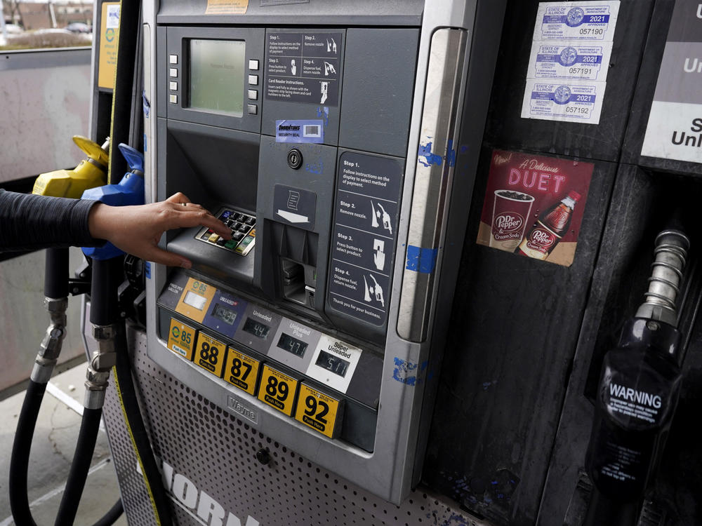 A woman prepares to fuel up at a gas station in East Dundee, Ill., on March 19.