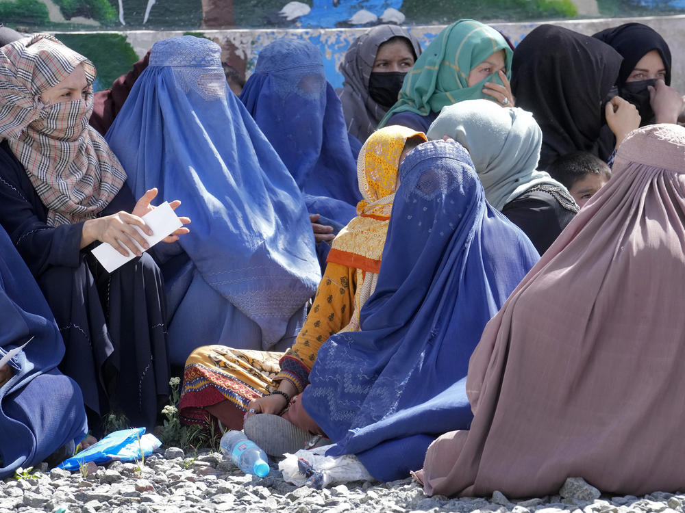 Afghan women wait to receive food rations distributed by a Saudi humanitarian aid group, in Kabul on April 25. Afghanistan's Taliban rulers on Saturday ordered all Afghan women to wear head-to-toe clothing in public.
