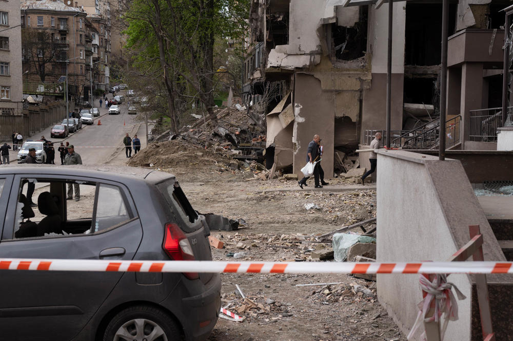 People return to a residential building in Kyiv to collect their belongings after it was damaged in a Russian missile strike last week.
