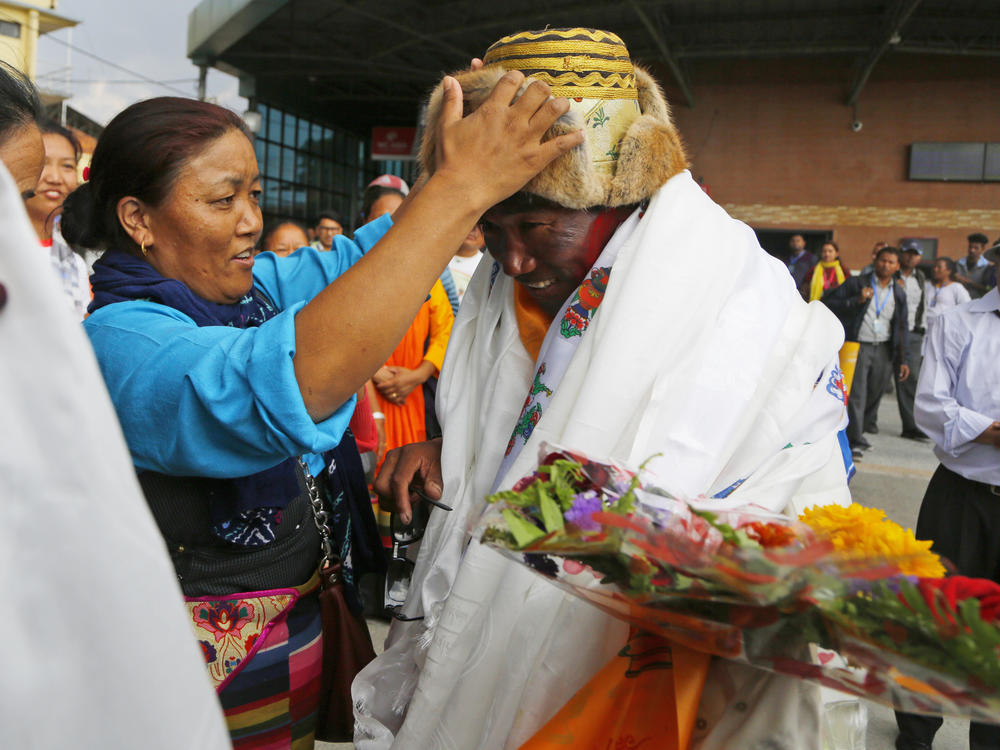 Friends and family congratulate Kami Rita, 48 at the time, in Kathmandu, Nepal, in May 2018 after setting a new world record for climbing Mount Everest 22 times.