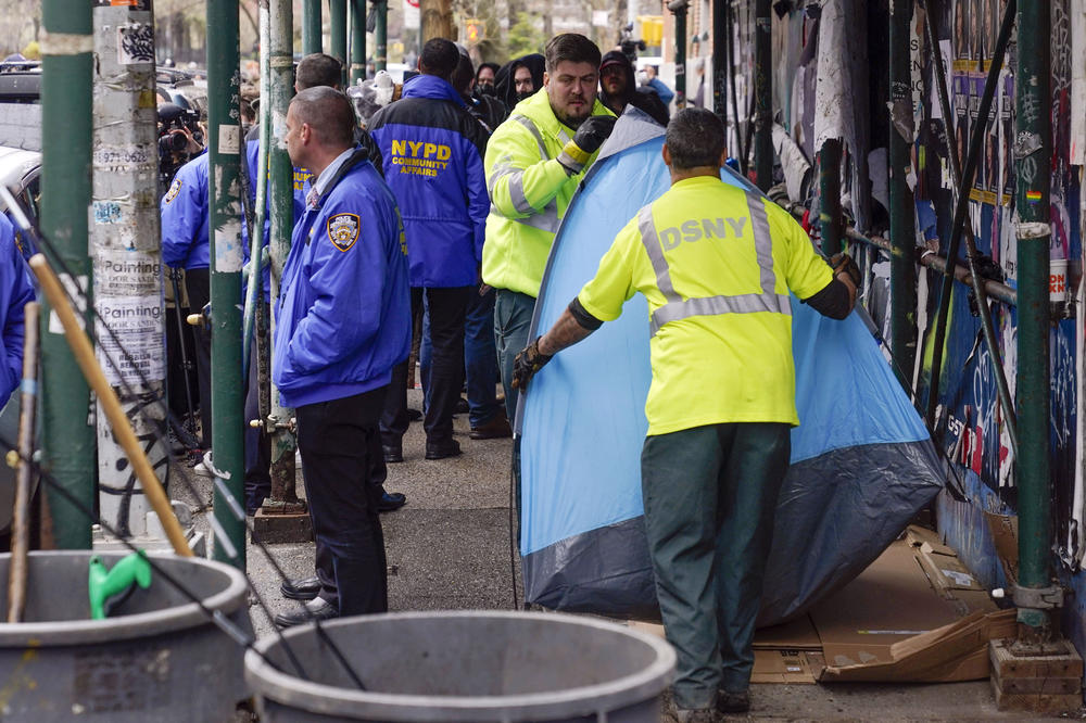 Sanitation workers moving a tent at a homeless encampment to a garbage truck in New York last month. The effort is part of a plan by Mayor Eric Adams to rid the city of people living in the streets.
